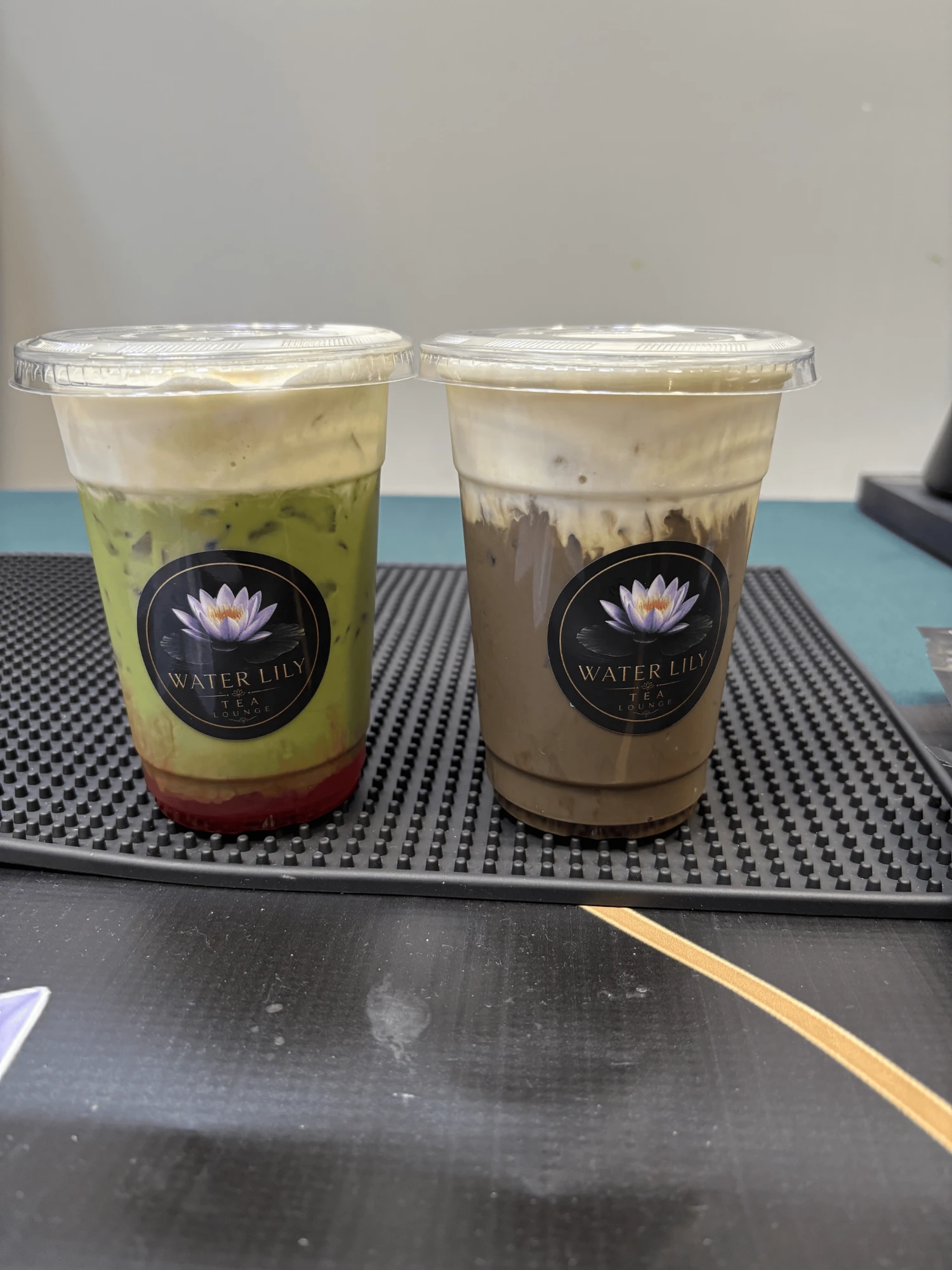 Two Water Lily drinks, a matcha and a mocha, side by side on the bar